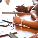 Black women executives taking notes in a board meeting