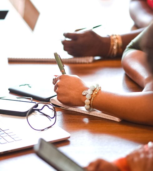 Black women executives taking notes in a board meeting